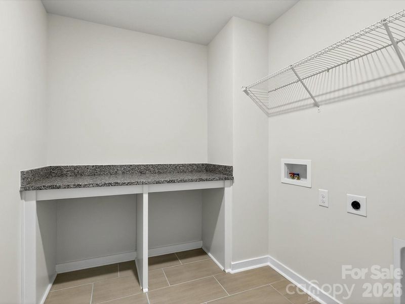 Laundry room with folding table with granite countertop