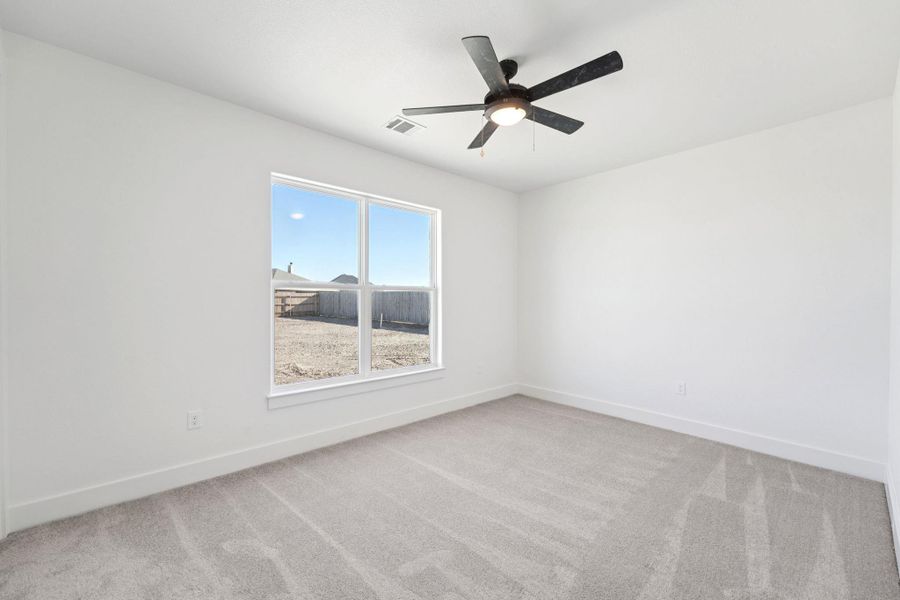 Empty room featuring light carpet and a ceiling fan