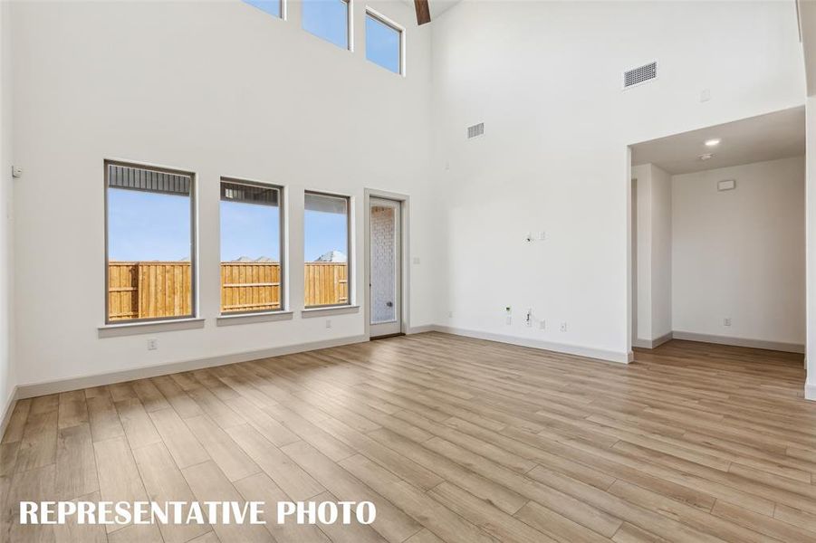A wall of windows flood this family room with natural light.  REPRESENTATIVE PHOTO