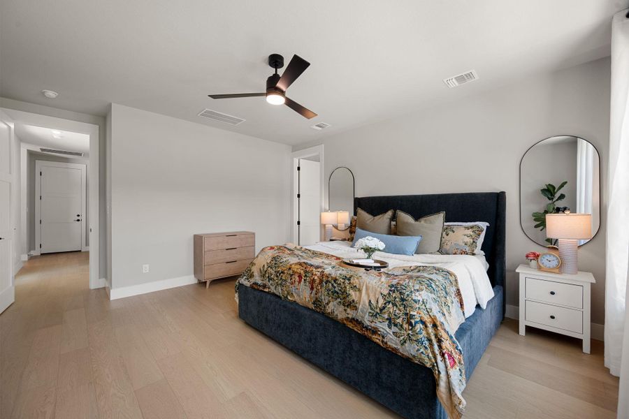 Smooth wood floors and crisp white trim create an inviting atmosphere in this bedroom.