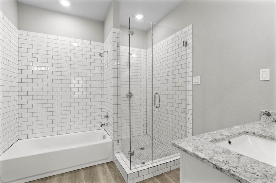 Primary bathroom offering a separate tub and shower.  Nicely done with subway tile and nice granite countertops.