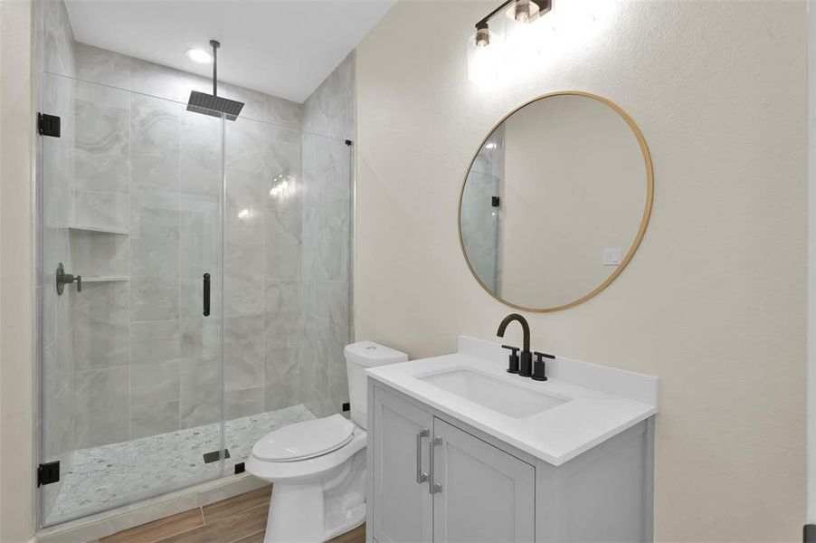 Secondary bath on the second floor with rain shower head and custom tile shelving.