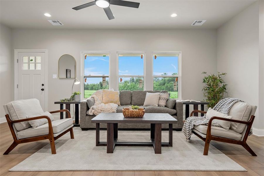 Bright living space featuring light wood-finish flooring and a neutral color palette