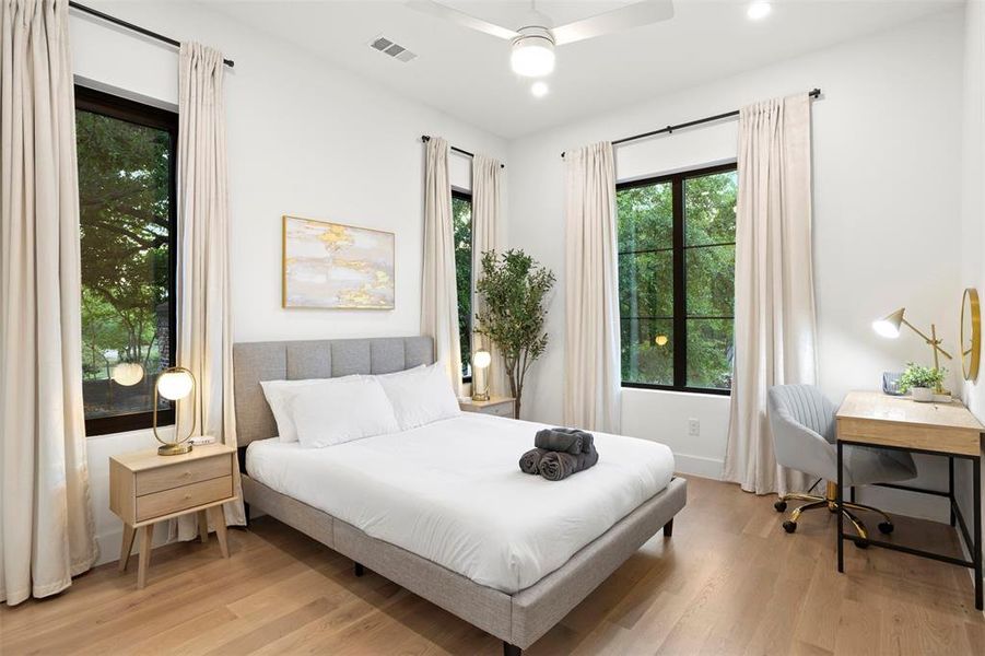 Bright room featuring wood-finish flooring, recessed lighting, and a ceiling fan