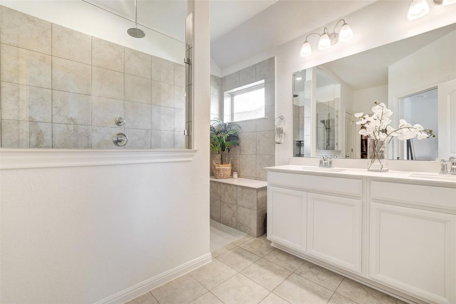 Bathroom with a walk in shower, tile patterned floors, and double vanity