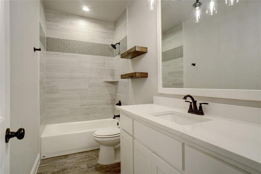 Bathroom featuring vanity,  shower combination, and wood tiled floors