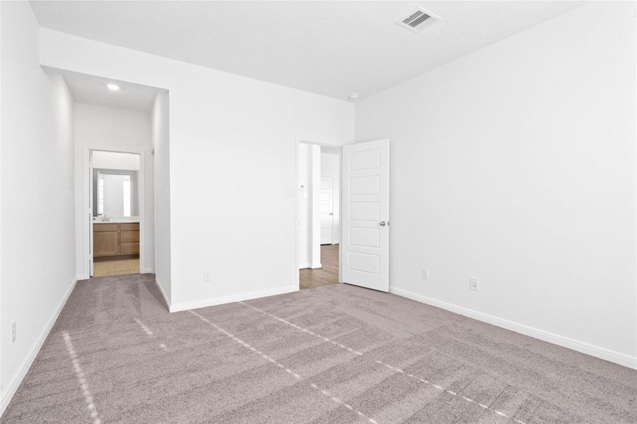 Additional view from primary bedroom looking down hallway to walk-in closet and primary bathroom.
