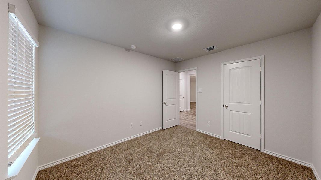 Unfurnished bedroom with carpet floors and baseboards