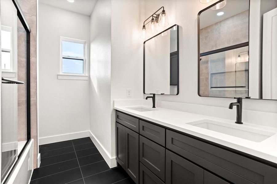 Full bathroom with a stall shower, double vanity, dark tile patterned floors, and recessed lighting Full bathroom with a stall shower, double vanity, dark tile patterned floors, and recessed lighting