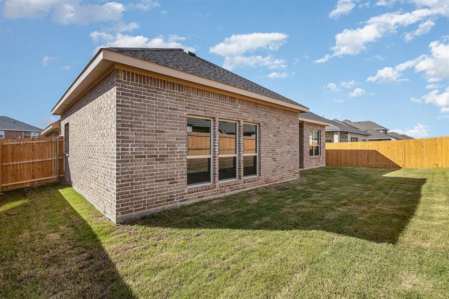 Rear view of house featuring a lawn