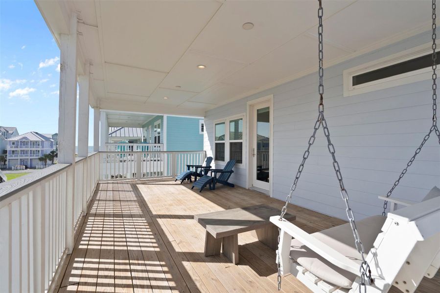 A refined extension of the primary suite, the private back porch offers a serene retreat for elevated everyday living. Lounge on the cozy swing as sunlight spills across the space, illuminating the curated seating area with warm wooden chairs and a breezy table. Ideal for tranquil mornings or golden-hour conversations, this sun-kissed escape adds a touch of resort-style comfort to your home. A refined extension of the primary suite, the private back porch offers a serene retreat for elevated everyday living. Lounge on the cozy swing as sunlight spills across the space, illuminating the curated seating area with warm wooden chairs and a breezy table. Ideal for tranquil mornings or golden-hour conversations, this sun-kissed escape adds a touch of resort-style comfort to your home.