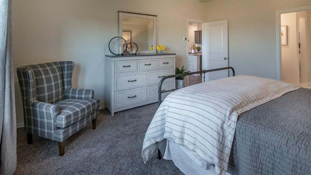Carpeted bedroom featuring a light-toned wall finish, a white paneled door, and a built-in closet