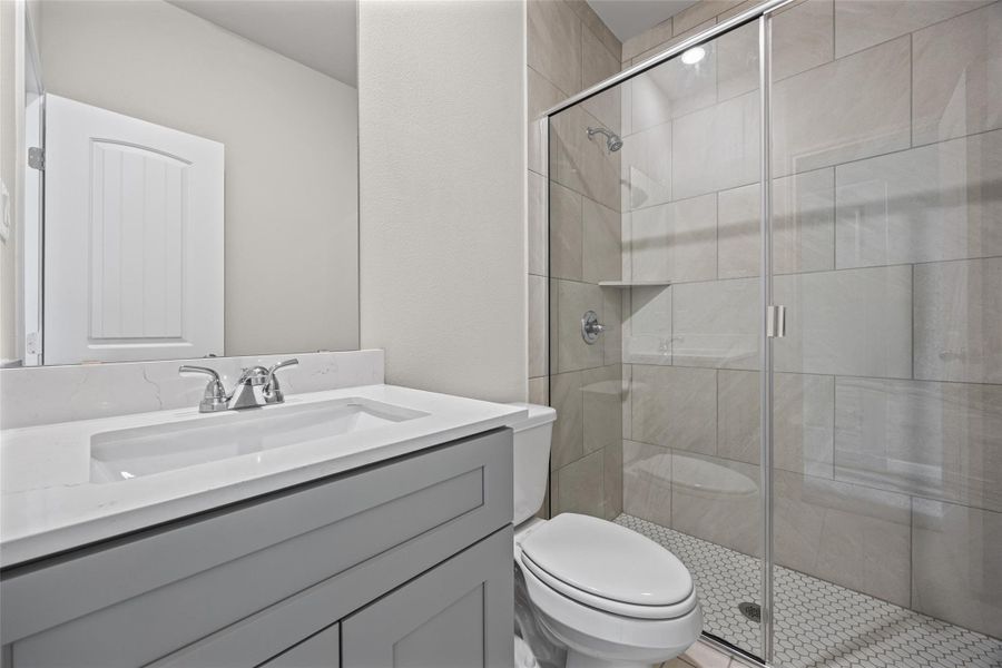 A glass-enclosed walk-in shower with tiled walls highlights this modern bathroom space. A glass-enclosed walk-in shower with tiled walls highlights this modern bathroom space.