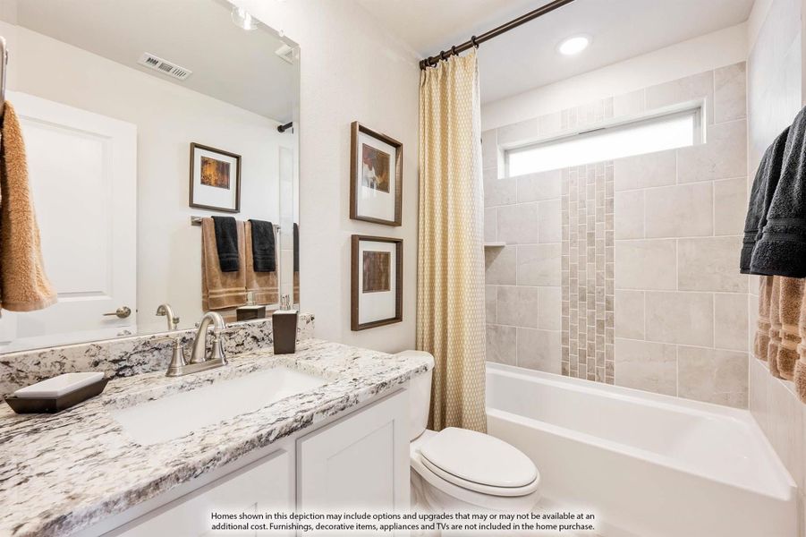 Bathroom with granite countertop vanity, white cabinets, and tiled tub-shower combo with curtain Bathroom with granite countertop vanity, white cabinets, and tiled tub-shower combo with curtain