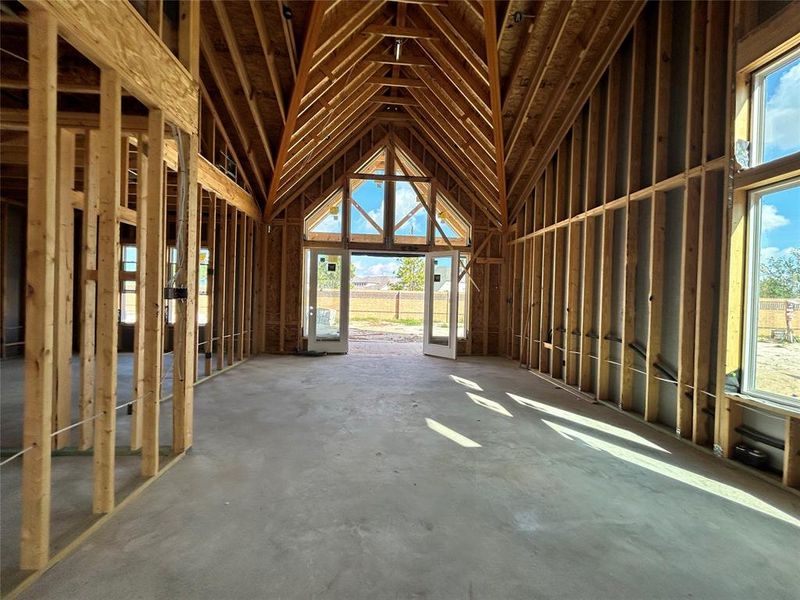 The living room is flooded with light and features tall vaulted ceilings.