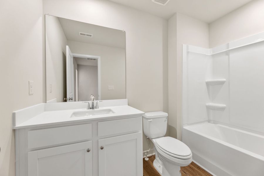 A bathroom with a tub sink and toilet.