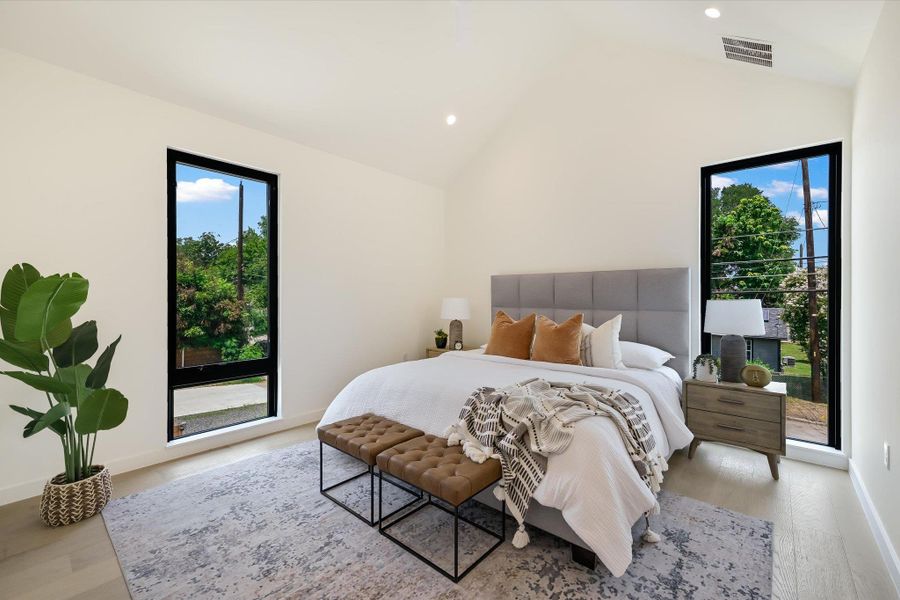 Bedroom featuring light wood finished floors, multiple windows, recessed lighting, high vaulted ceiling, and access to outside