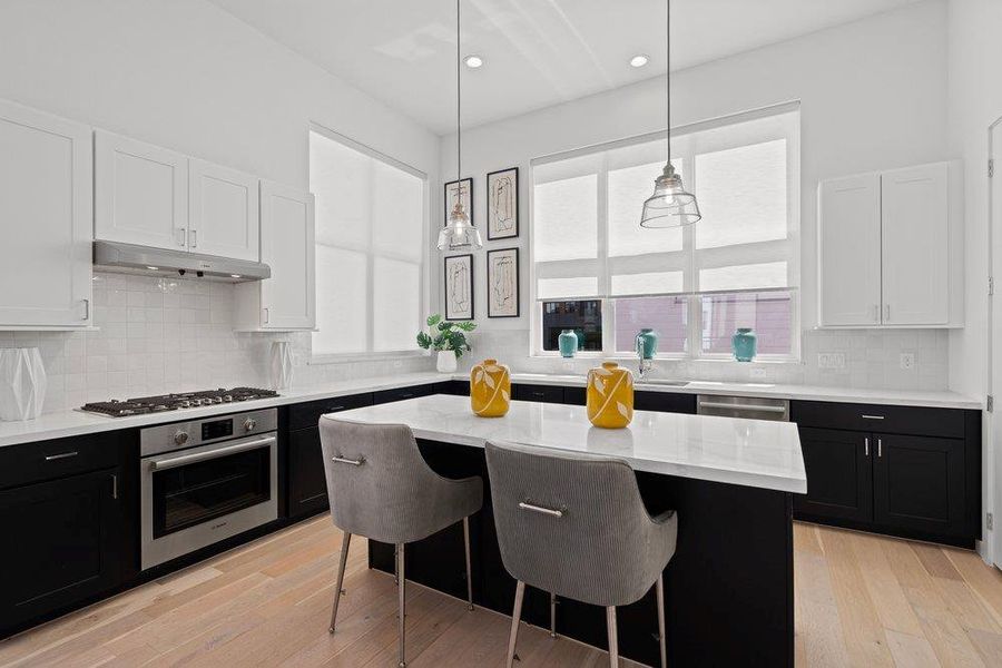 Culinary delights await in this modern kitchen with an inviting island, crisp white subway tile backsplash, and ample cabinetry. Culinary delights await in this modern kitchen with an inviting island, crisp white subway tile backsplash, and ample cabinetry.