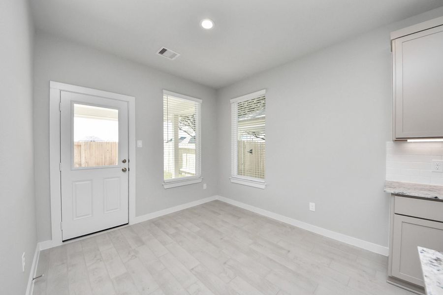 Enjoy breakfast with ease in the connected and cozy breakfast area, seamlessly integrated with the kitchen for utmost convenience. Step through the back door for a breath of fresh air onto the covered patio, extending your living space to the outdoors. Sample photo of completed home with similar floor plan. Actual colors and selections may vary.