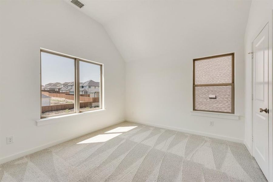 Unfurnished room featuring vaulted ceiling and carpet floors Unfurnished room featuring vaulted ceiling and carpet floors