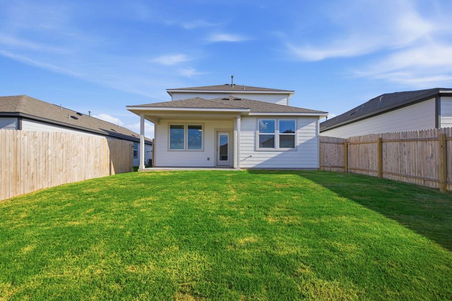 A spacious, enclosed yard provides a private outdoor retreat with a covered patio for enjoyment.