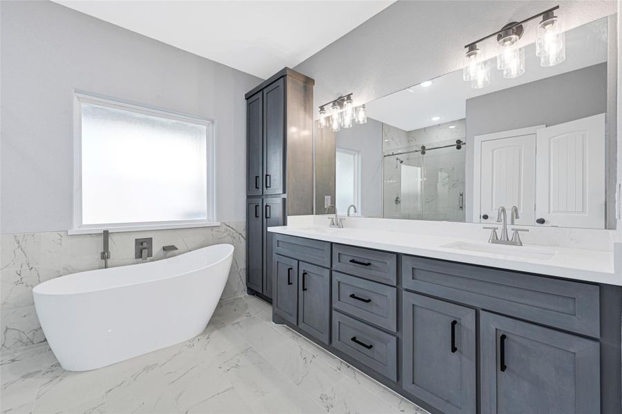 Master bedroom downstairs with double sink, soaking tub and walking shower