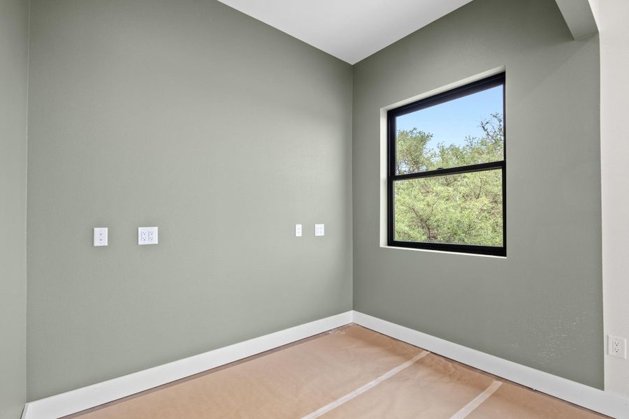 Neutral-toned walls with a large single-hung window featuring a black frame