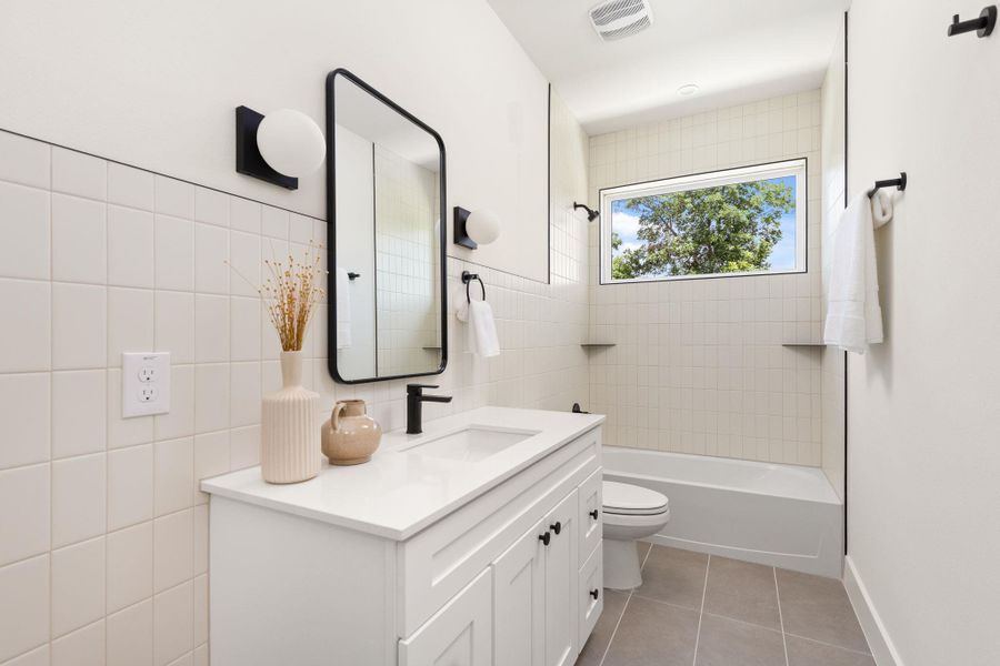 Modern bathroom featuring a vanity with a sleek black faucet and a bathtub with a view of verdant trees. Modern bathroom featuring a vanity with a sleek black faucet and a bathtub with a view of verdant trees.