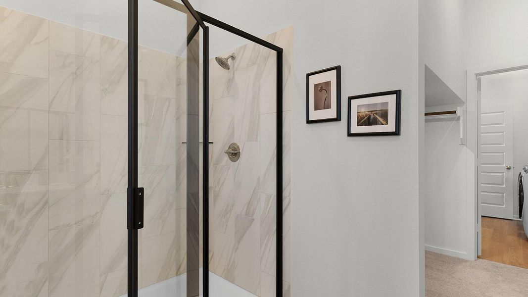 A chic shower stall features elegant tilework and a contemporary black-framed glass enclosure. A chic shower stall features elegant tilework and a contemporary black-framed glass enclosure.