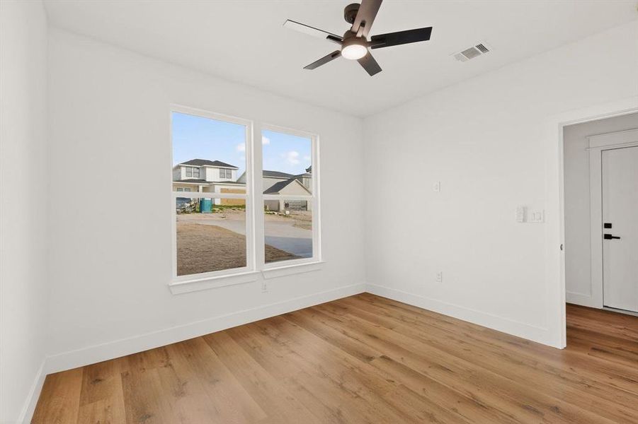Empty room featuring light wood-style floors and a ceiling fan Empty room featuring light wood-style floors and a ceiling fan