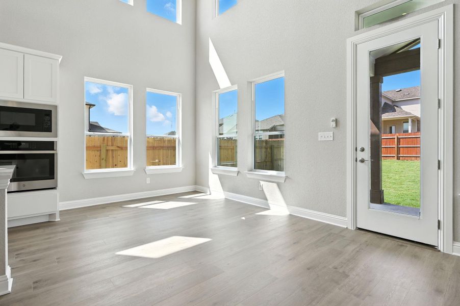 Unfurnished dining area with light wood-style floors and a high ceiling