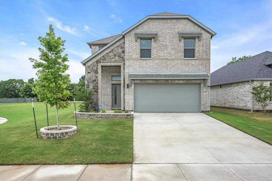 Front of property featuring a garage and a front lawn