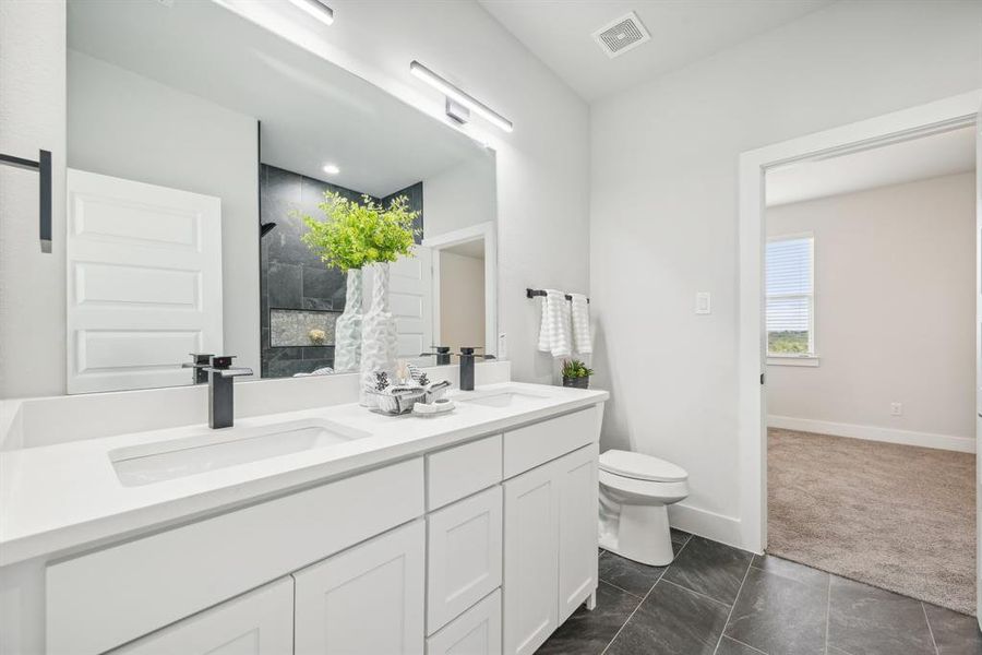 Bathroom with vanity, toilet, a shower, and tile patterned flooring