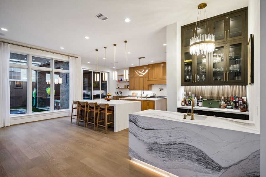 This stunning bar is ideally situated just off the dining room and seamlessly opens to both the den and kitchen, perfect for entertaining.