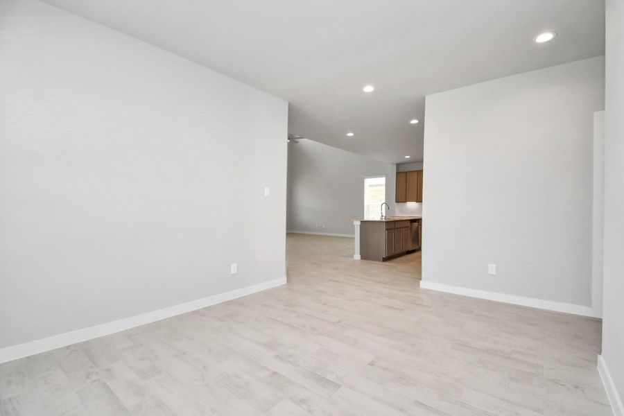 Make memories gathered around the table with your family and friends in this spacious dining room. Features elegant flooring, custom paint, and adjacent to family room and kitchen for open concept feel. Sample photo of completed home with similar floor plan. Actual colors and selections may vary.