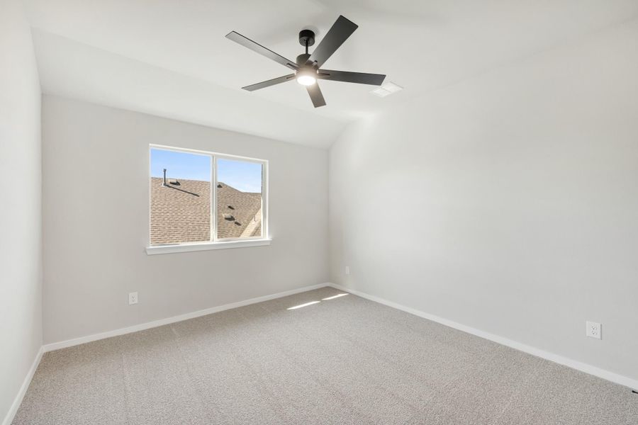 Empty bedroom with vaulted ceiling, ceiling fan, carpet flooring, and single window