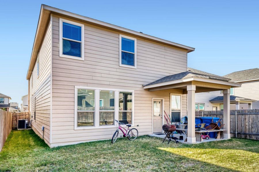 Rear view of property featuring a fenced backyard and a patio
