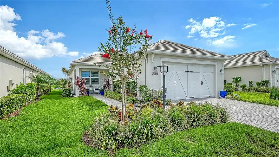 Front exterior of a new home in LakeHouse Cove at Waterside, Sarasota, FL, highlighting curb appeal (Image 1). Front exterior of a new home in LakeHouse Cove at Waterside, Sarasota, FL, highlighting curb appeal (Image 1).