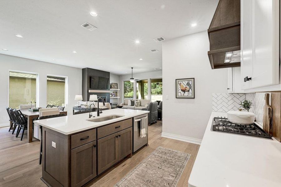 Kitchen with light wood finished floors, an island with sink, recessed lighting, open floor plan, and decorative backsplash Kitchen with light wood finished floors, an island with sink, recessed lighting, open floor plan, and decorative backsplash