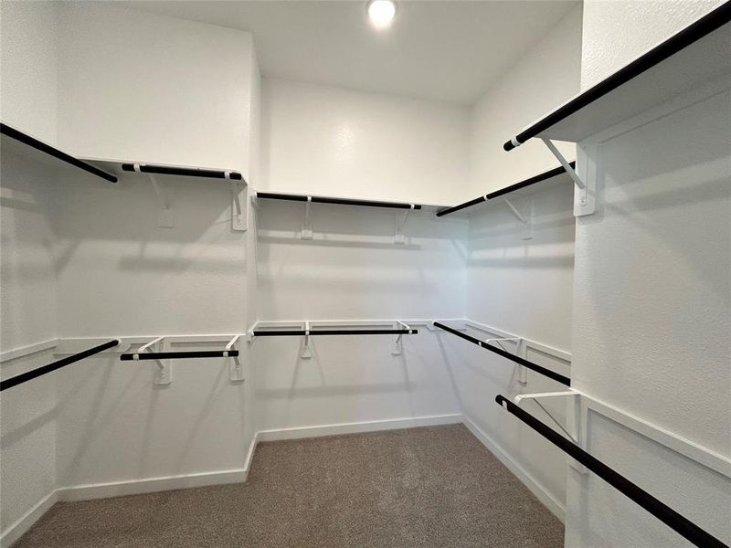 The closet space is spacious and organized, with ample shelves and hanging rods, offering plenty of room for storage and easy access to clothing and accessories.