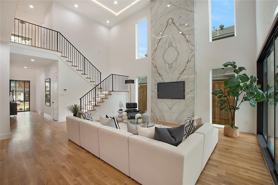 Living room featuring a high ceiling and light hardwood / wood-style flooring