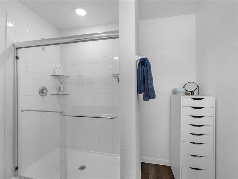 This additional view of your primary bathroom features neutral paint, and large walk-in shower.