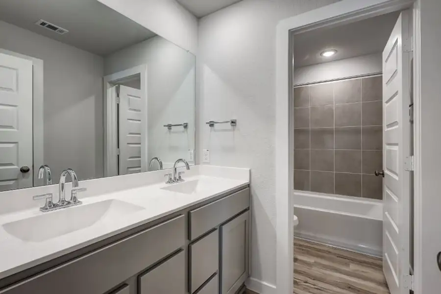 A bathroom with a sink and a shower.