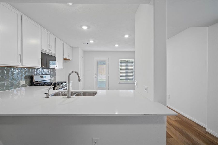 Any chef's dream, this stunning kitchen is perfect for everyday life as well as entertaining family and friends! Extra large breakfast bar is perfect for conversation or that much needed space to lay out your party spread for everyone to enjoy! Featuring stained cabinets, silestone countertops, modern backsplash, stainless steel appliances, recessed lighting, and custom paint.