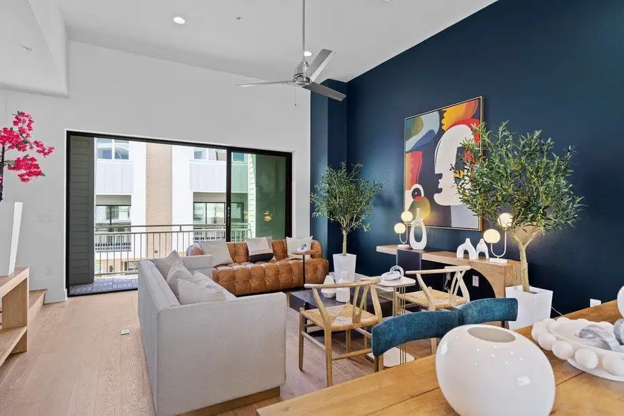 Living room featuring wood finished floors, ceiling fan, and a high ceiling