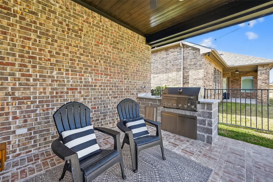 Covered patio with outdoor seating and built-in grill station. Covered patio with outdoor seating and built-in grill station.