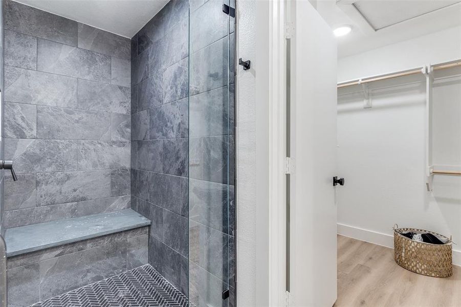 Bathroom with a tile shower and wood-type flooring