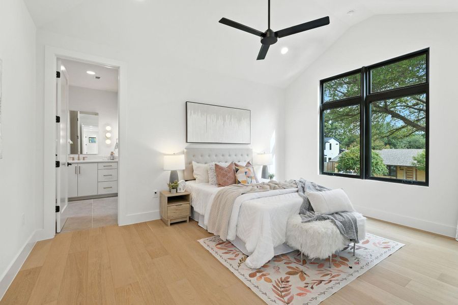 Bedroom with vaulted ceiling, recessed lighting, light wood-style floors, ceiling fan, and ensuite bath Bedroom with vaulted ceiling, recessed lighting, light wood-style floors, ceiling fan, and ensuite bath