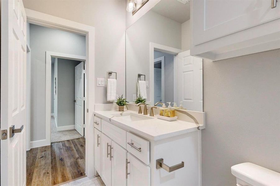 Bathroom featuring vanity, wood-type flooring, and toilet