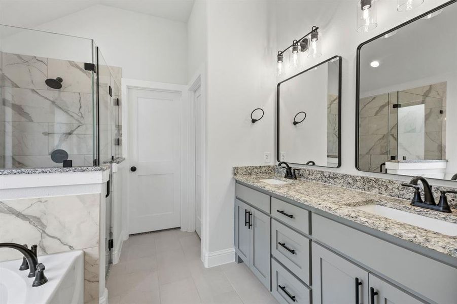 Bathroom featuring double vanity, a garden tub, a marble finish shower, and light tile patterned floors